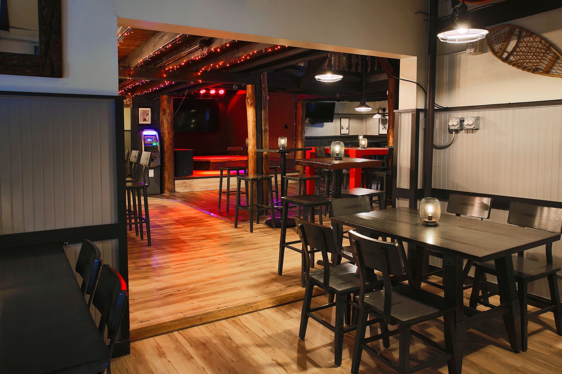 A restaurant with tables and chairs and a stage in the background.