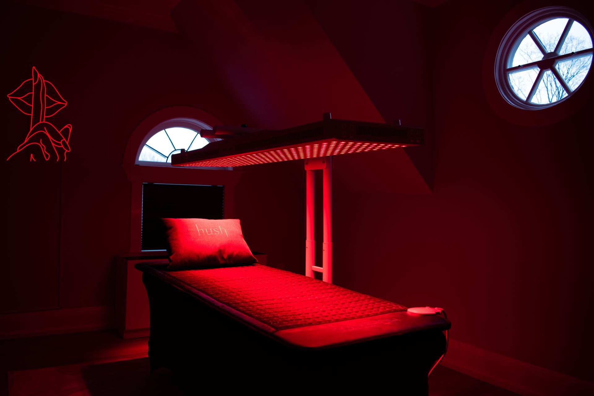 a bed with red lights on it in a dark room .