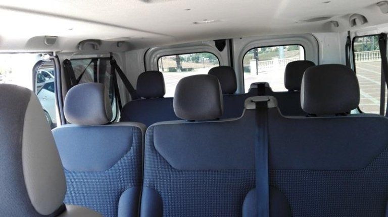 L'interno di un furgone con sedili blu e poggiatesta neri