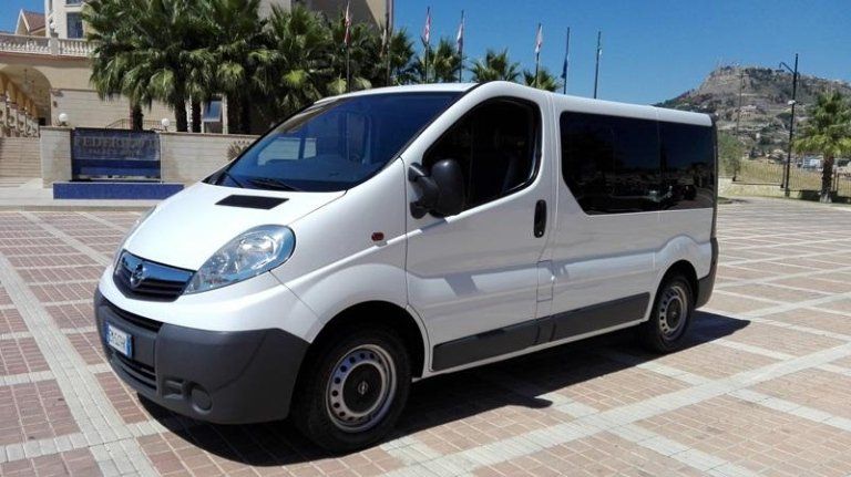 Un furgone bianco è parcheggiato su un marciapiede di mattoni di fronte a un edificio