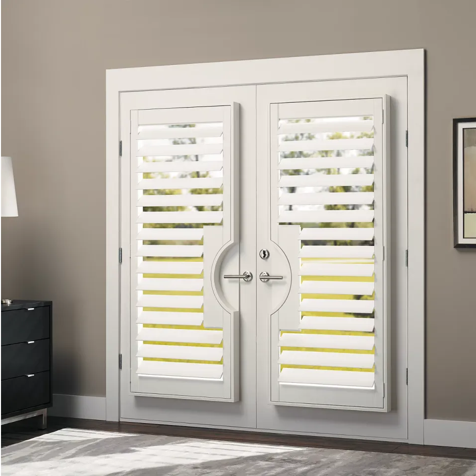 White double doors with built-in shutters, in a beige room, with dark cabinet and art.