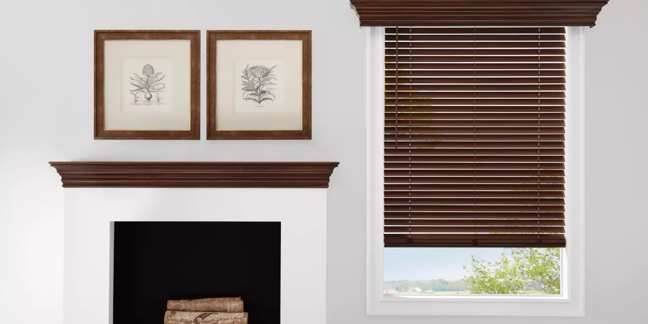 Interior scene with fireplace, framed art, and window with brown blinds.