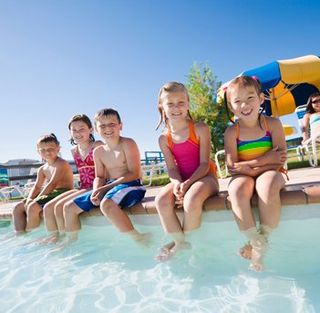 Kids sitting by pool — Pool Cleaning and Maintenance in Gettysburg, PA