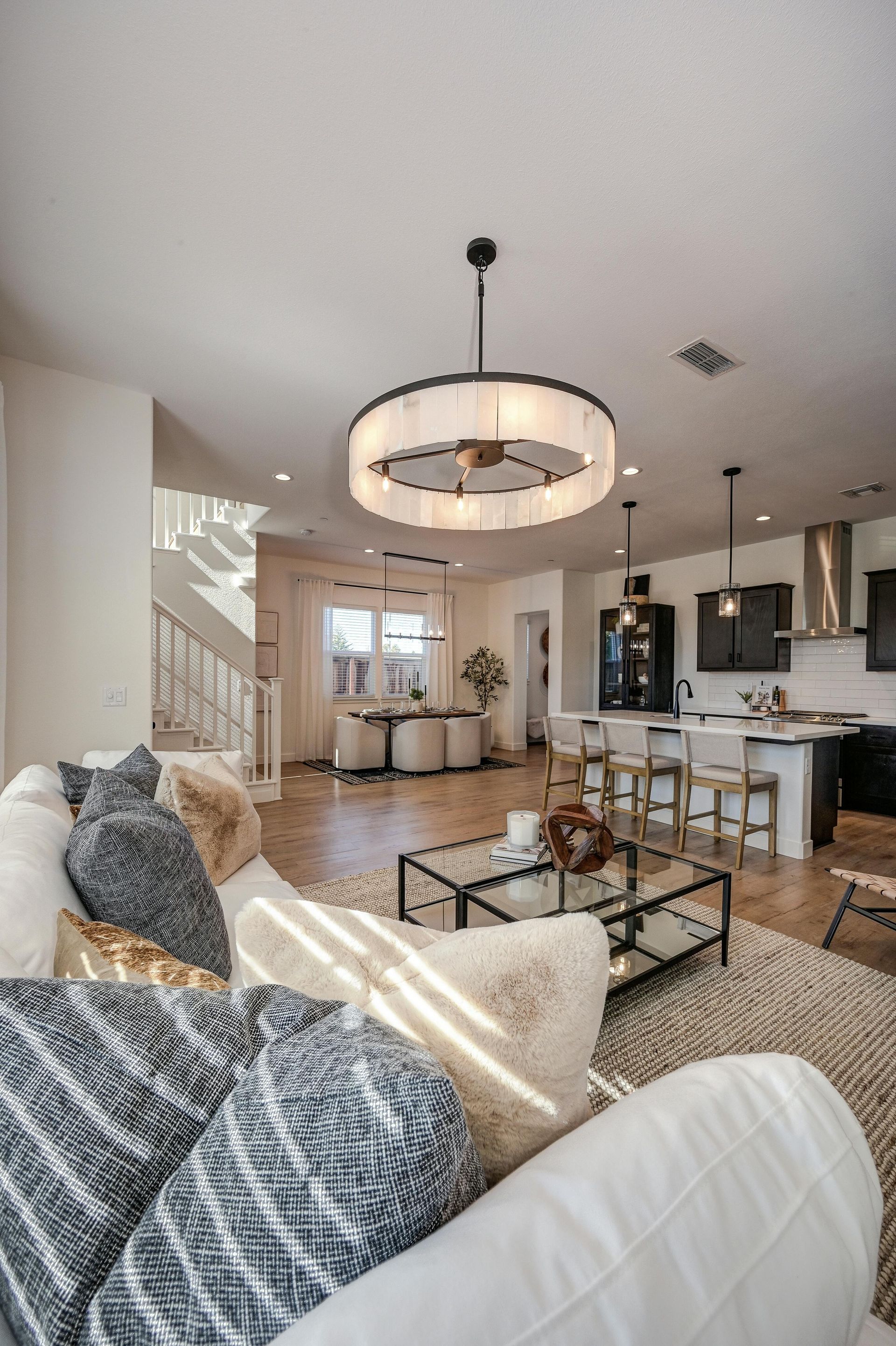 Homme lissant du papier peint avec une truelle ; motif feuille de palmier bleu, portant un t-shirt noir avec logo.