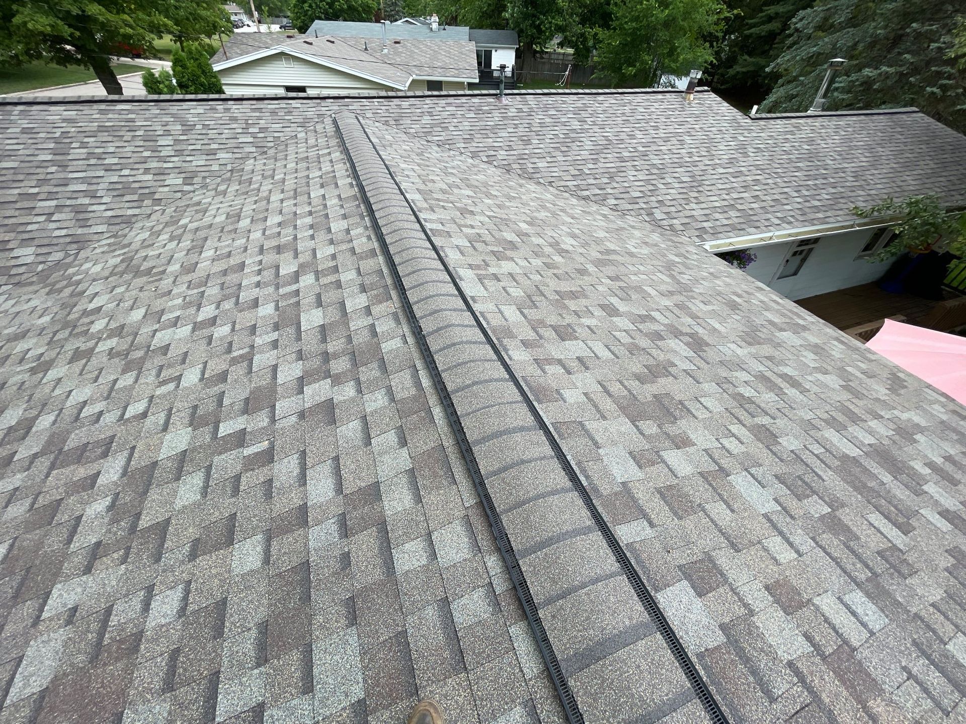 Overhead view of a roof with gray and brown shingles.