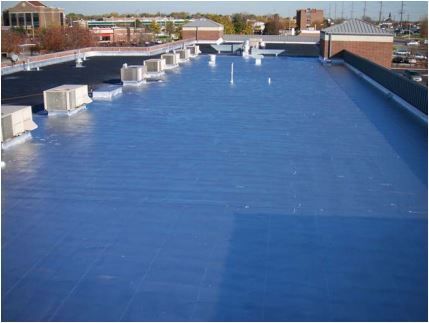 Blue coated flat commercial roof with HVAC units.