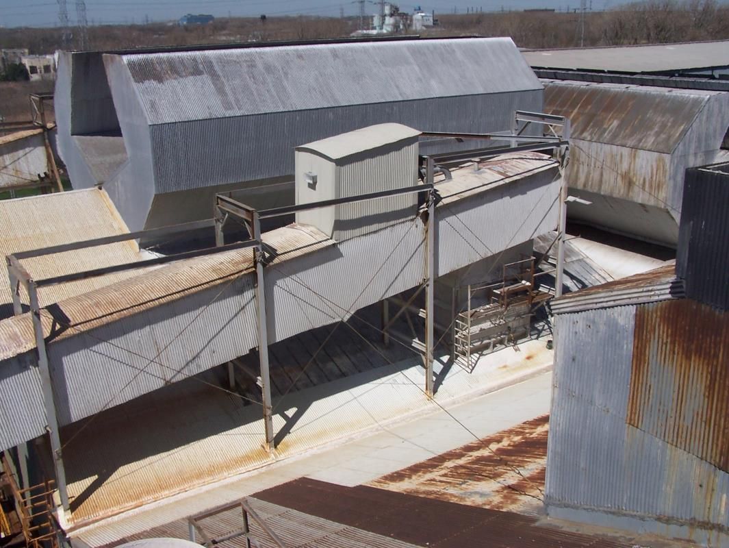 Corrugated metal industrial buildings with elevated walkways.