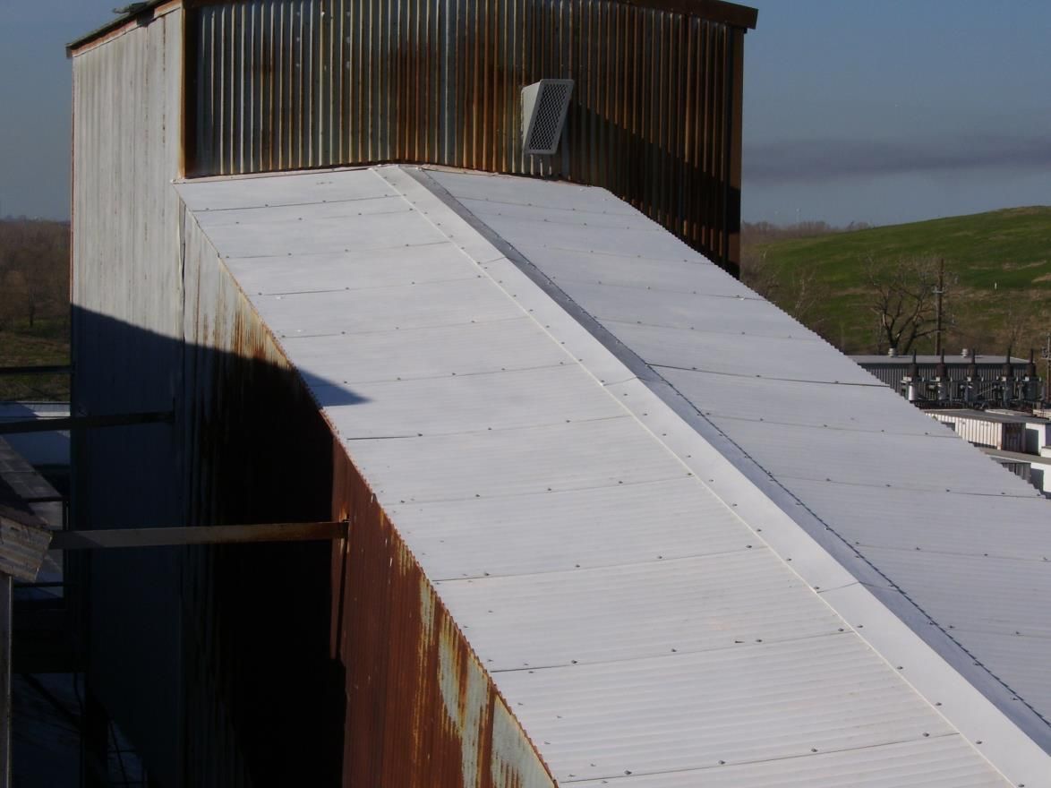 White painted metal ramp on a weathered industrial building.