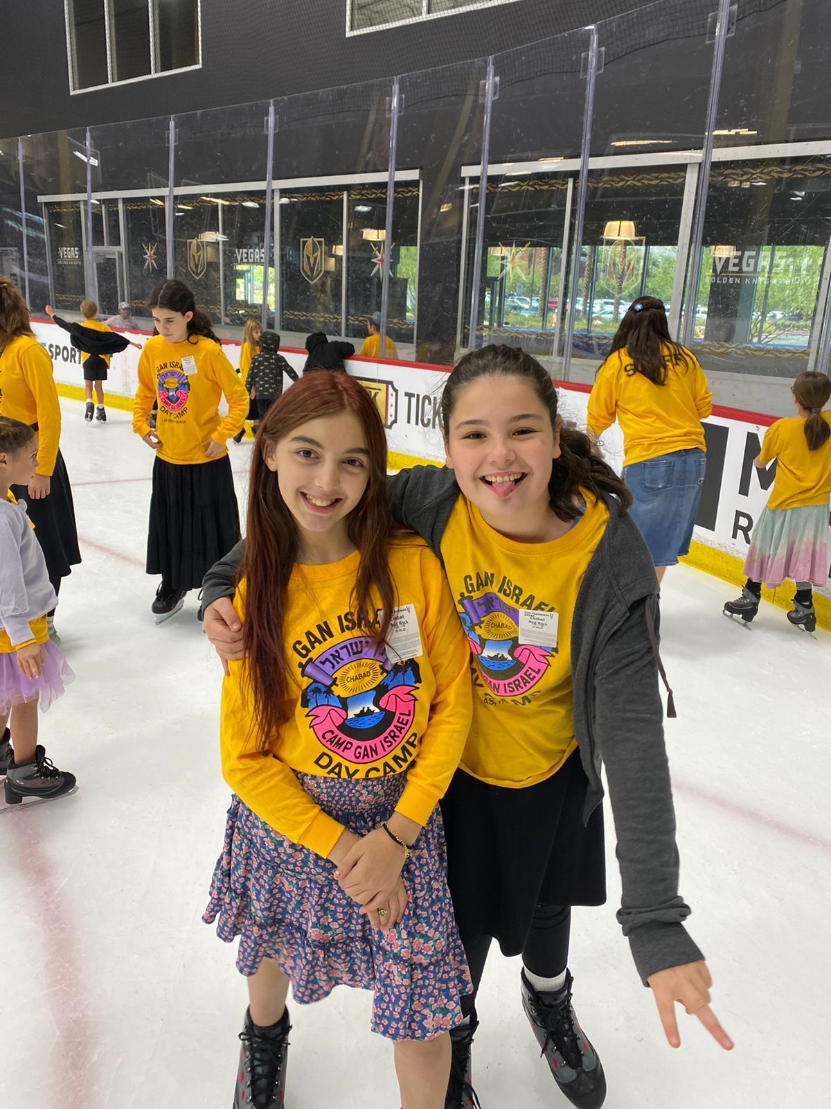 A group of about a dozen children and teens in matching long-sleeve yellow 