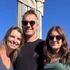 Família de três pessoas posa em frente à estátua do Cristo Redentor no Rio de Janeiro, Brasil.