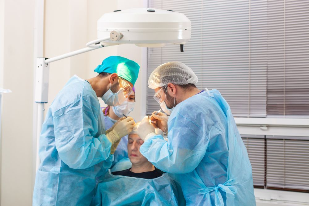 Surgeons perform a procedure in a brightly lit operating room.
