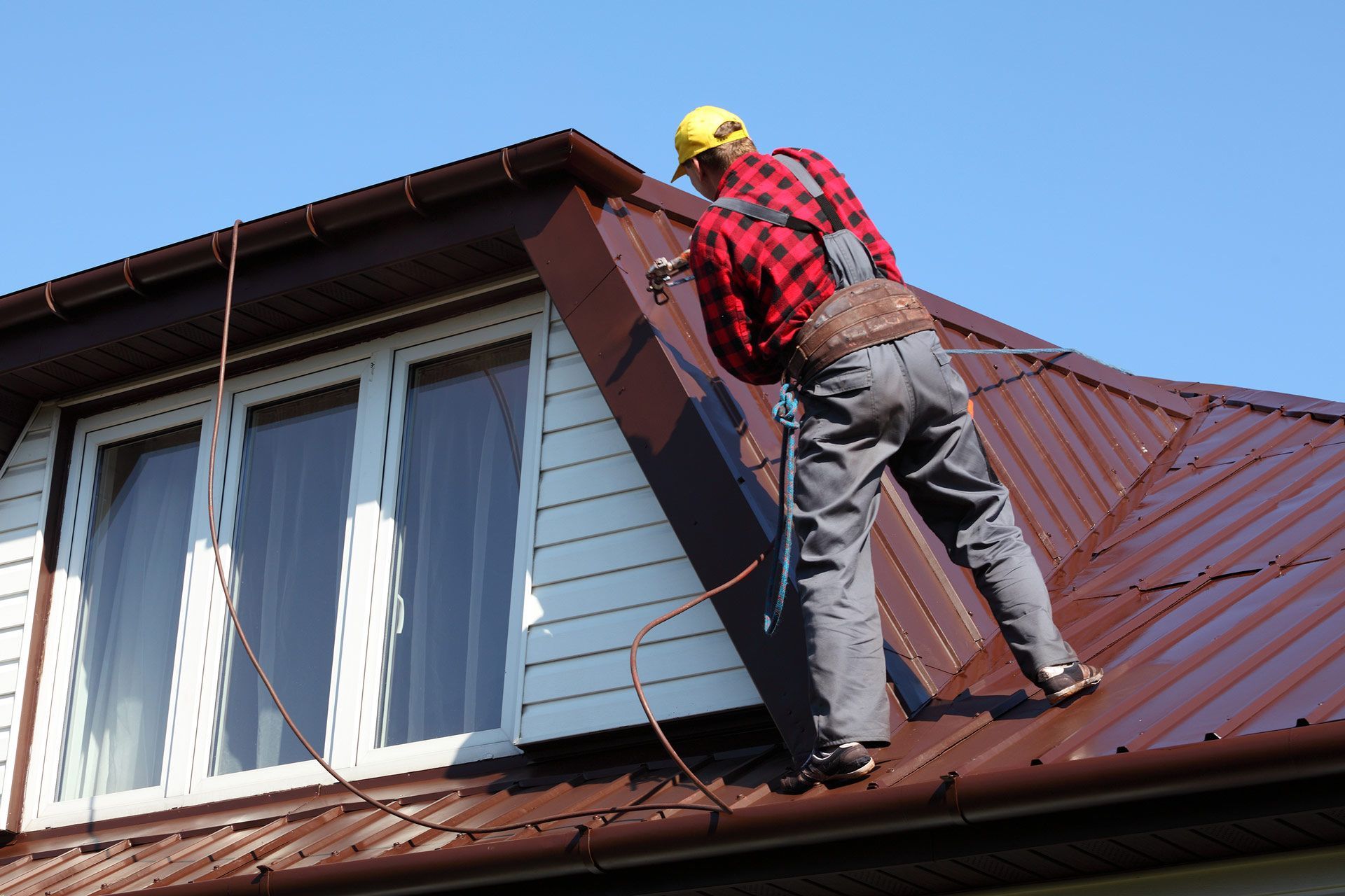 A man is working on the roof of a house.