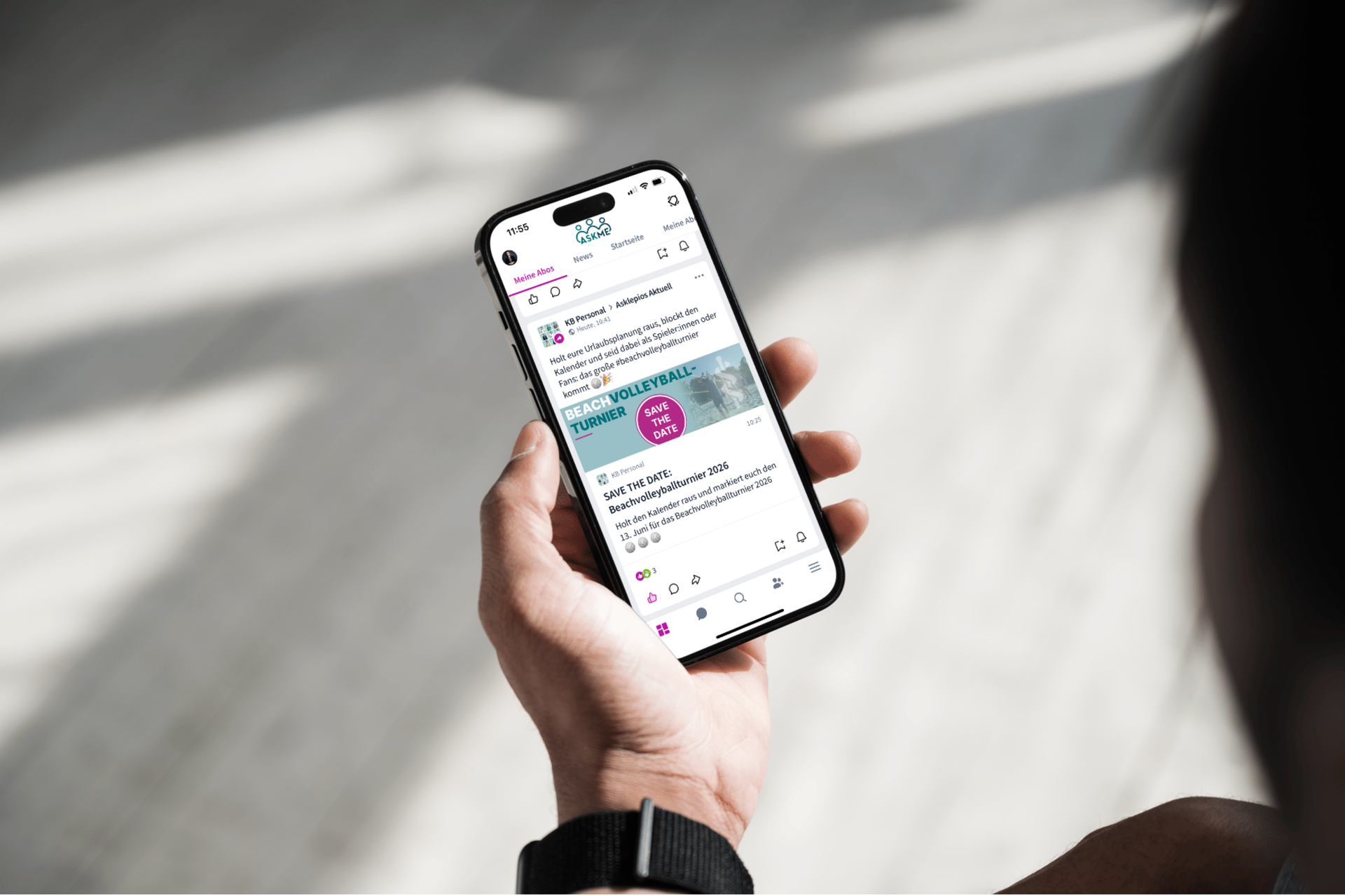 Ein Asklepios Mitarbeiter:in hält ein Smartphone in der Hand mit der Mitarbeiterapp ASKME von Haiilo