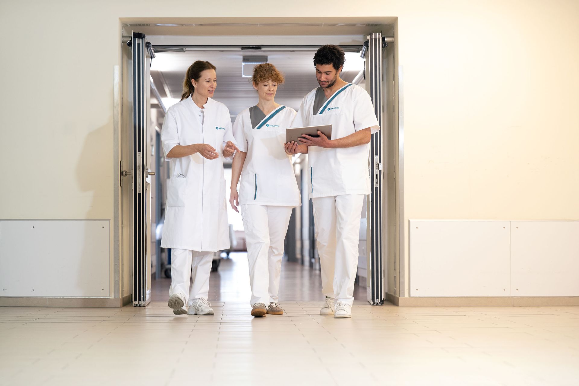 drei Krankenpfleger von Asklepios im Krankenhausflur