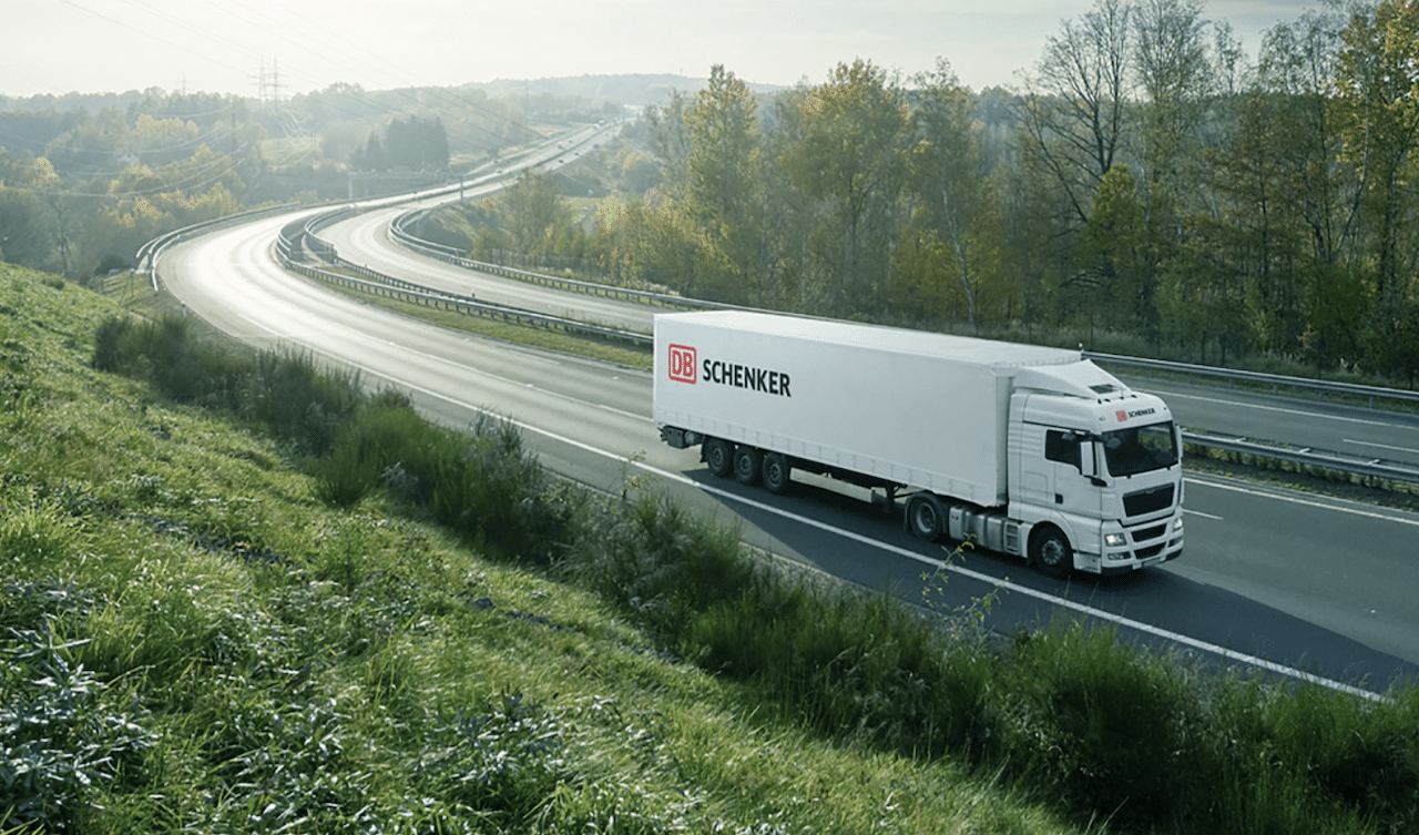 A white semi truck is driving down a curvy highway.