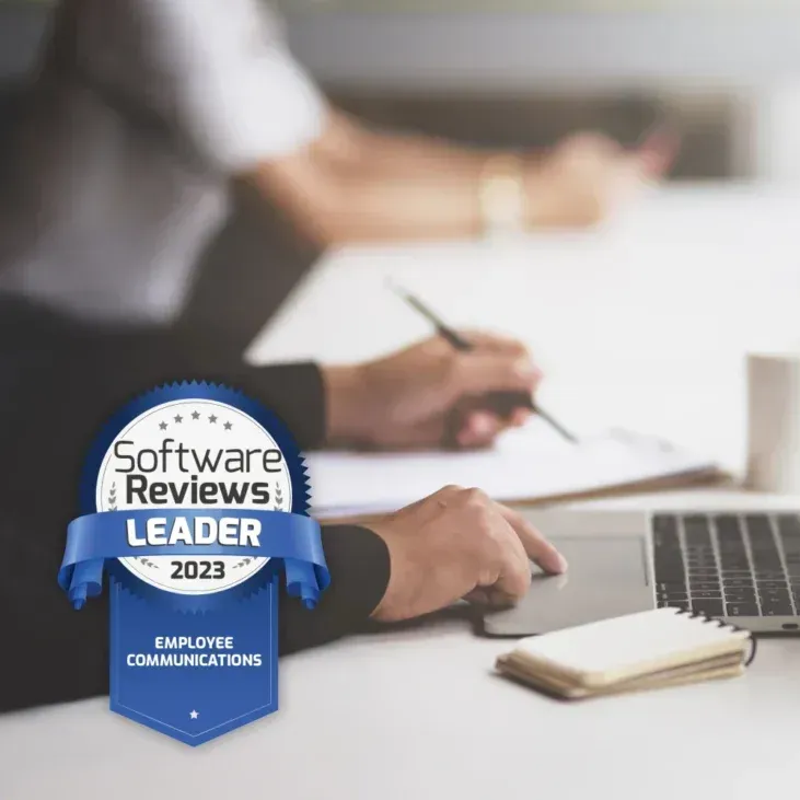 A person sitting at a desk with a software reviews leader badge