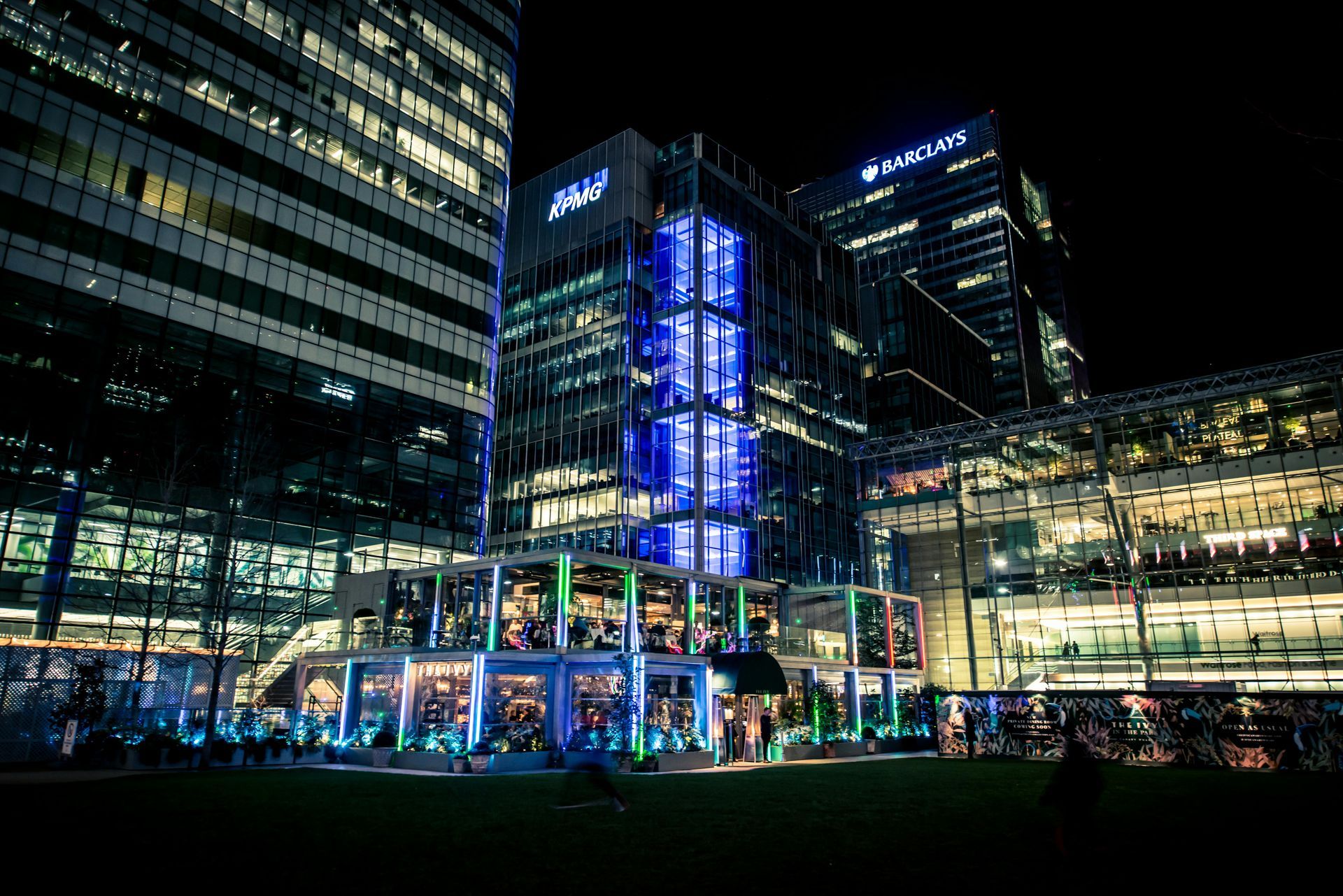 A large building with a blue light on it is lit up at night