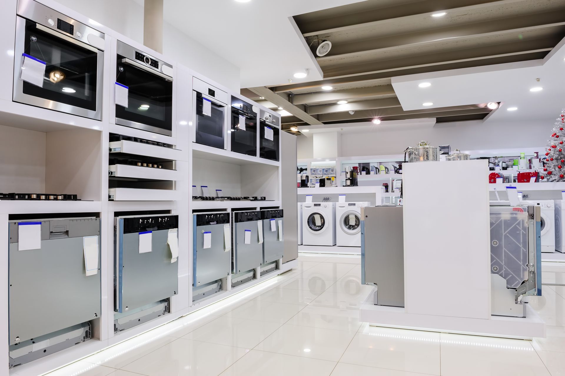A store filled with lots of appliances including a washing machine , dishwasher , oven , and microwave.