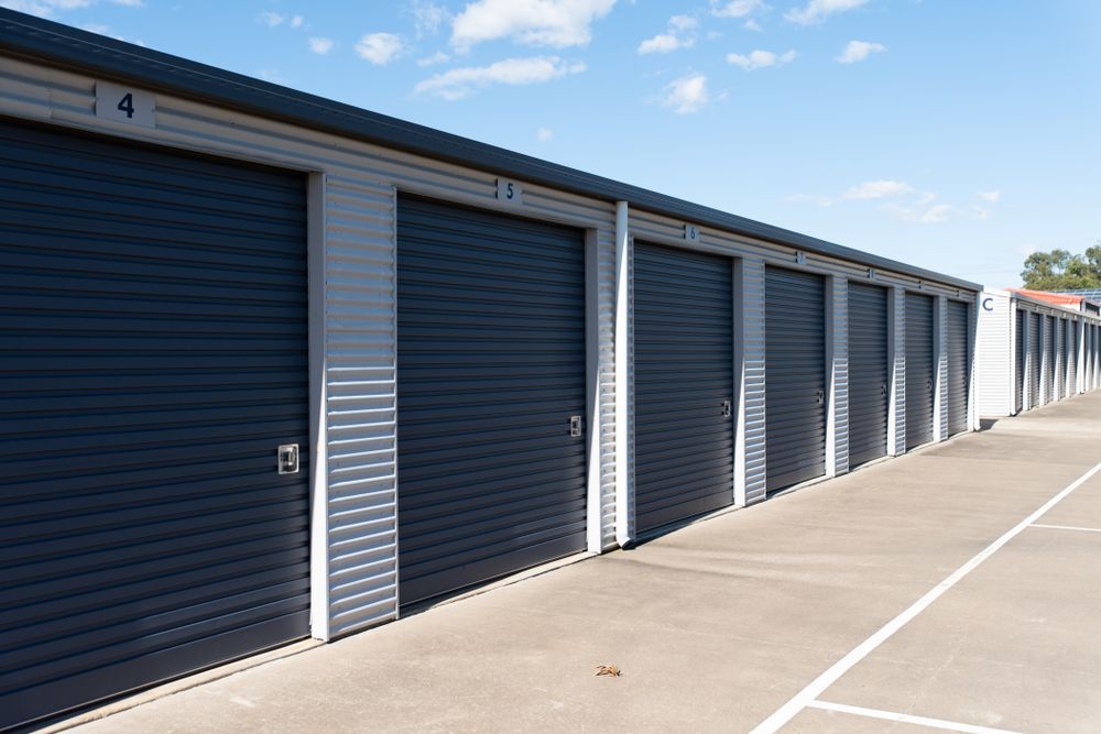 A Row of Storage Units With Black Doors in a Parking Lot — Secura Storage In Pialba, QLD