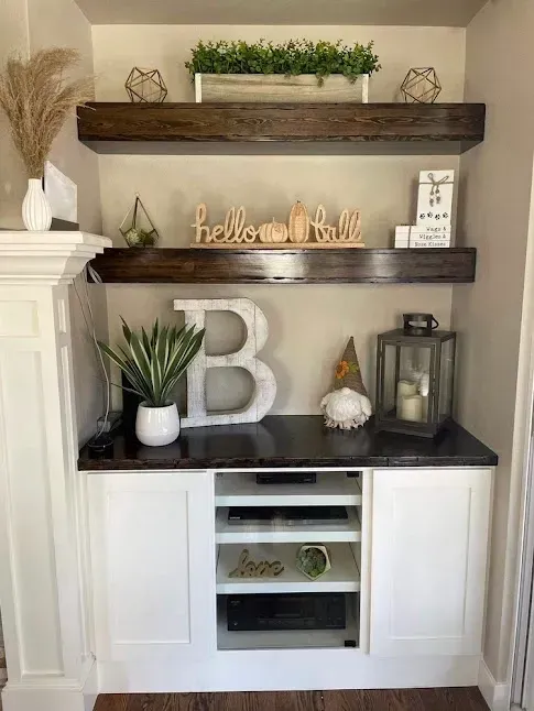 Built-in cabinet with shelves decorated with plants, decor, and a wooden
