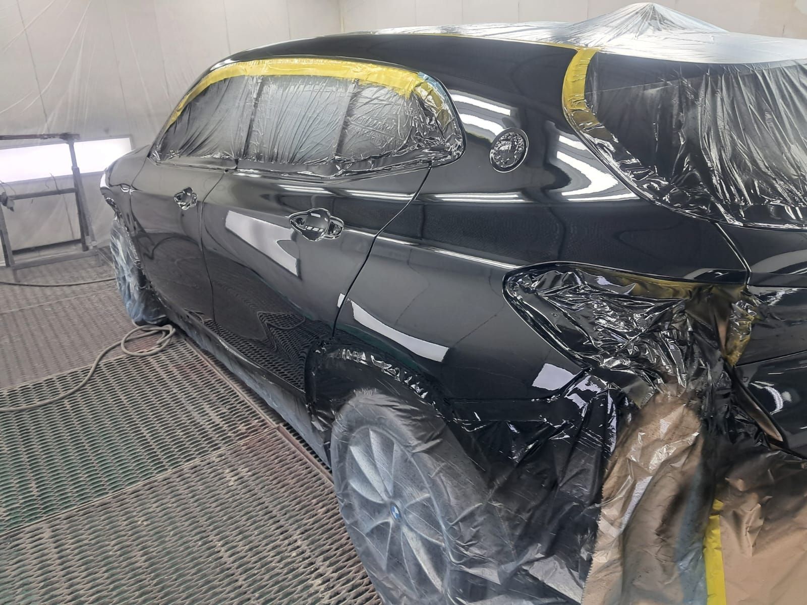 Piccola auto elettrica color tortora parcheggiata in un garage.