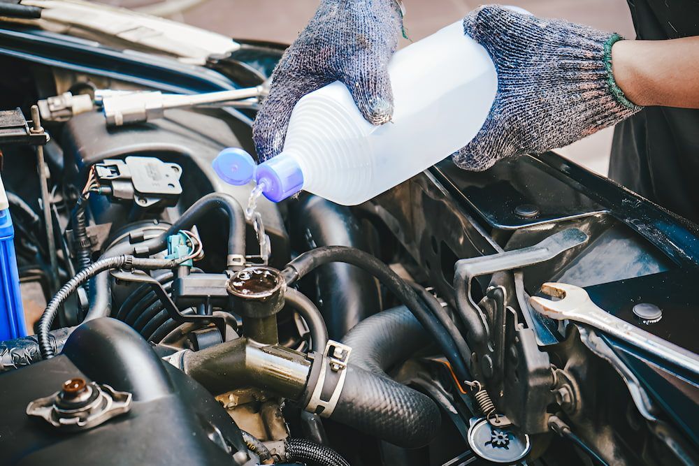 A Person is Pouring Water Into a Car Engine — Cartech Australia in Thurgoona, NSW