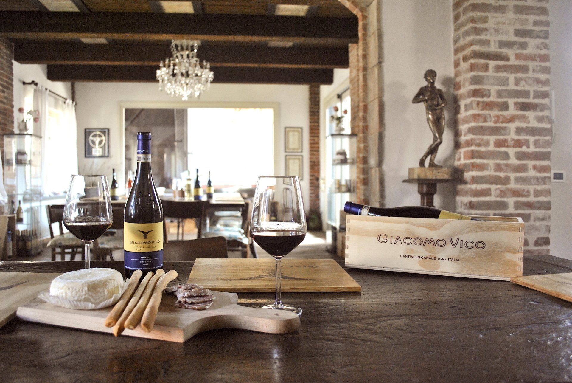 table with a glass of wine and a board with snacks