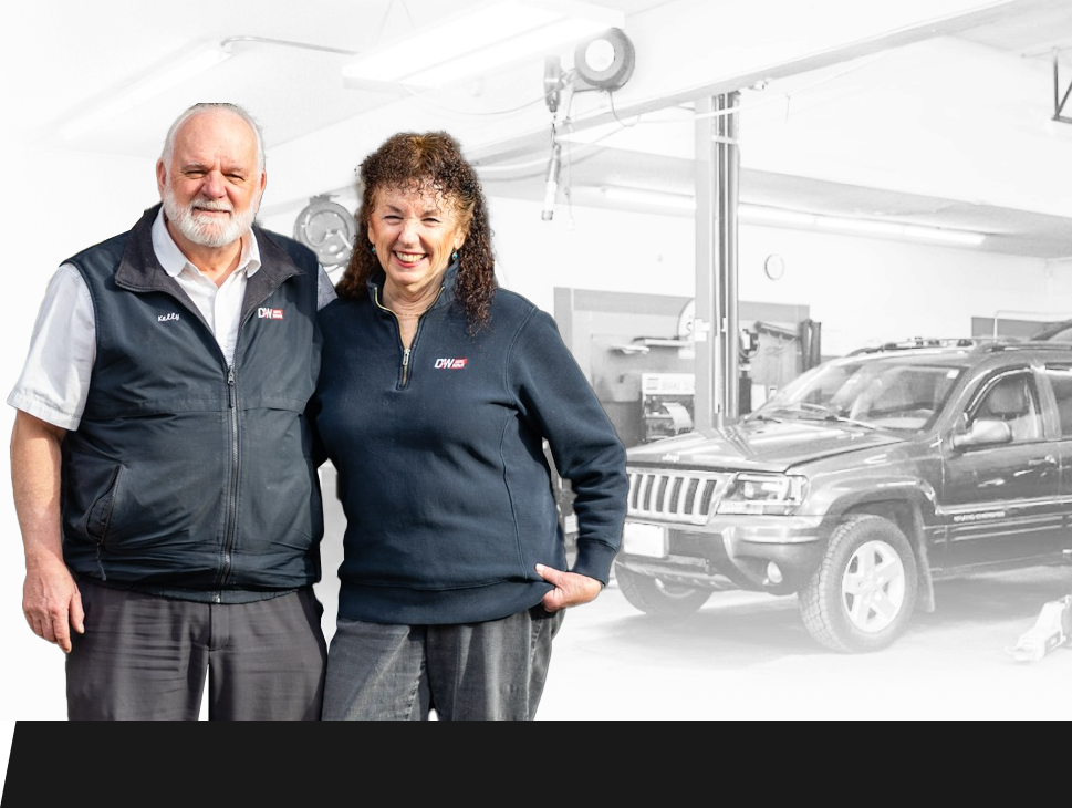 A man and a woman are standing next to each other in front of a jeep. | D&W Auto Repair