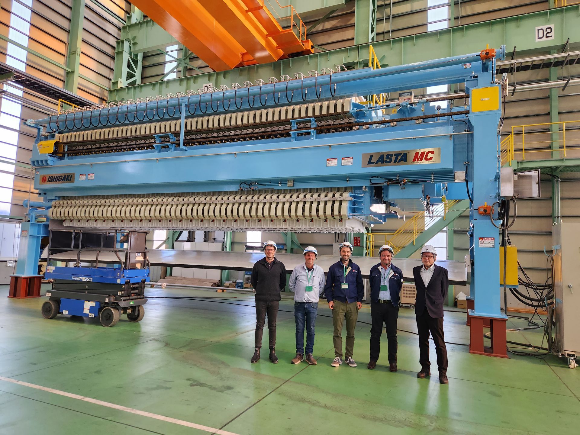 Aerial view of quarry; heavy machinery loading and processing gravel with conveyor belts.