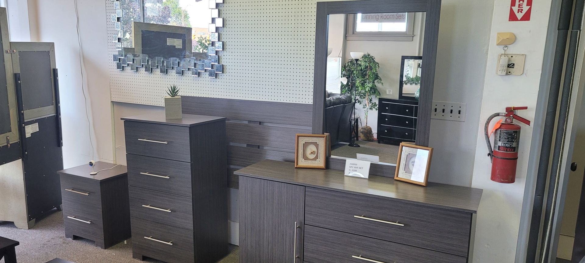 Bedroom furniture set in dark gray, including a dresser, mirror, and two chests.
