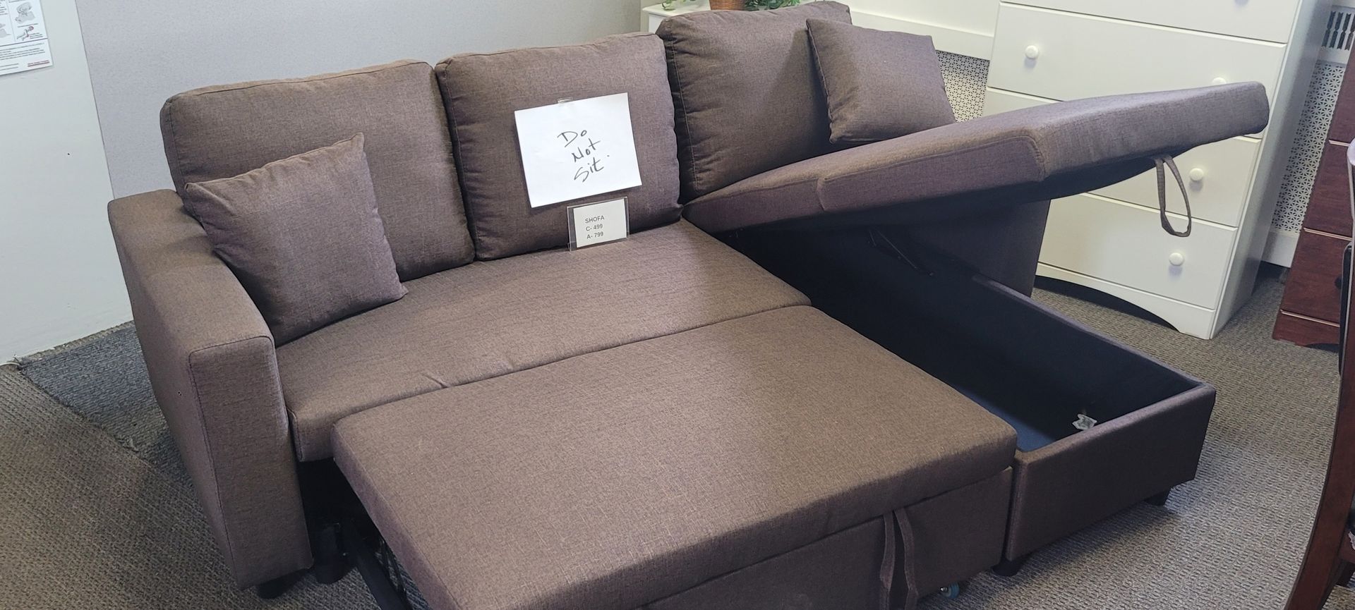 Brown sectional sofa with a chaise lounge that opens for storage.