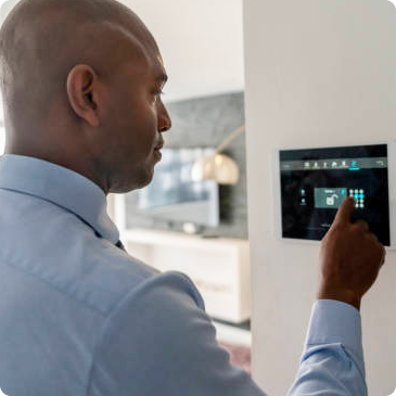 A man is pressing a button on a security system.