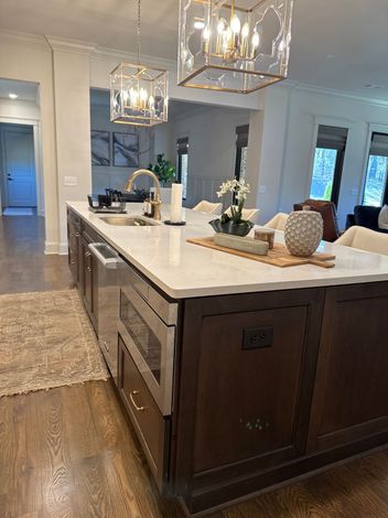 Standard recurring cleaning for a client in Moores Mill A beautifully cleaned kitchen in Auburn's Moore's Mill neighborhood, featuring a polished designer light fixture and sparkling countertops by Polished Oak Cleaners.
