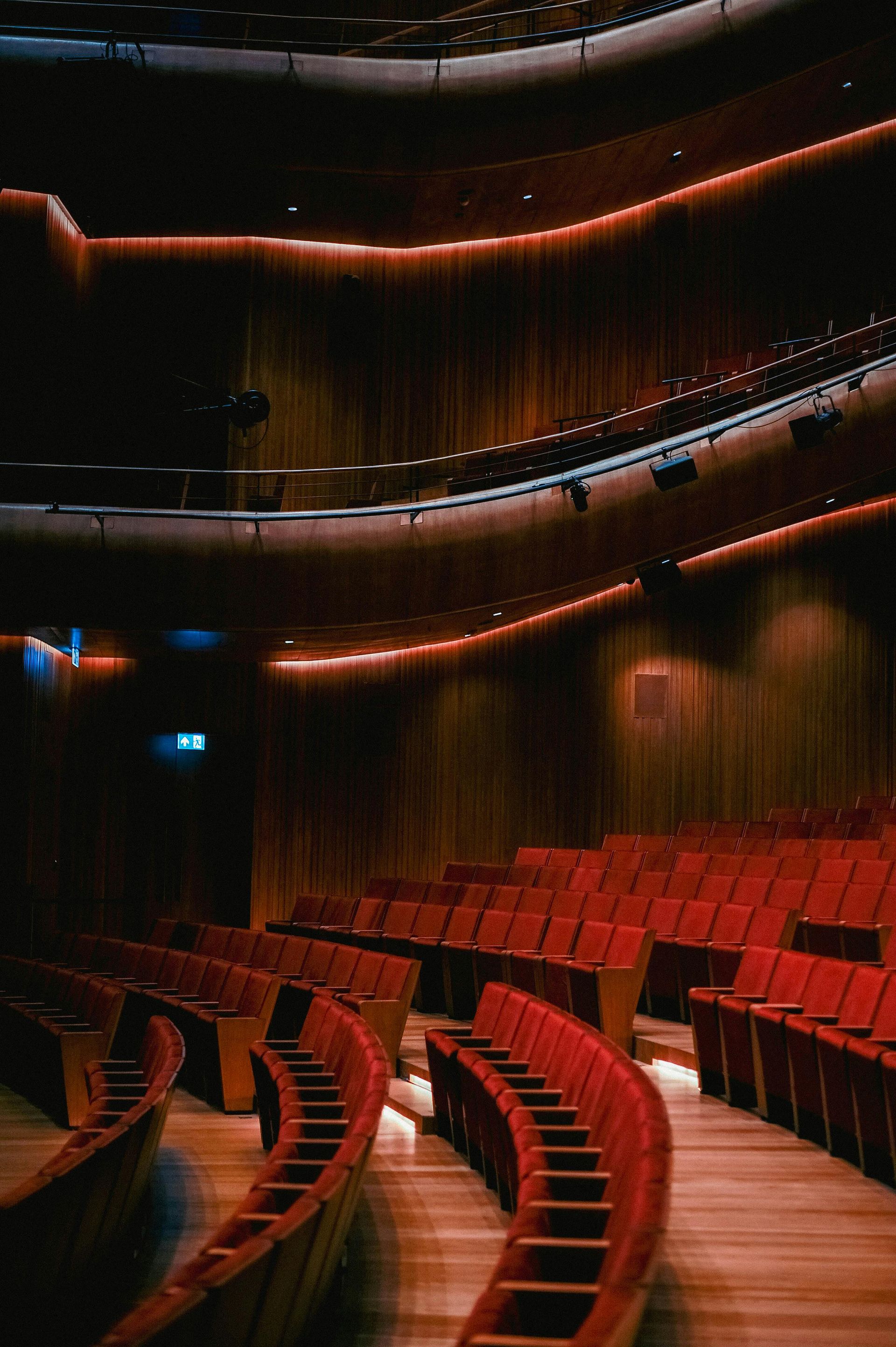 An empty auditorium with rows of red seats