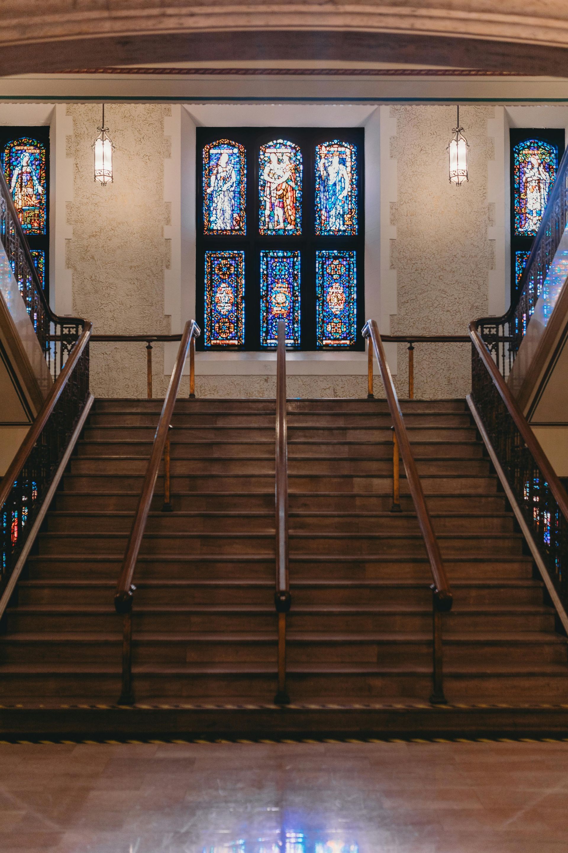 A staircase with a stained glass window in the background
