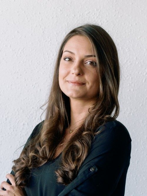 A woman in a black shirt is smiling for the camera.