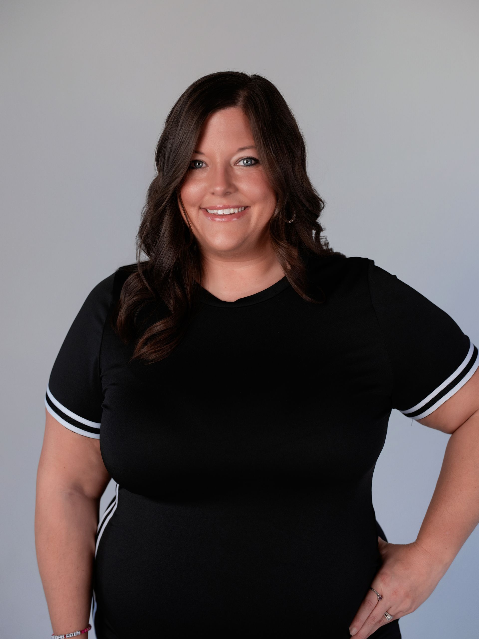 A woman in a black shirt is smiling for the camera.