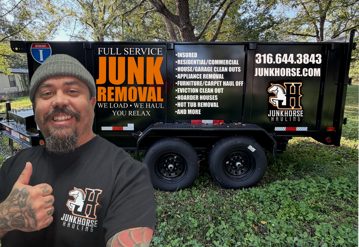 Man with tattoos and beanie giving thumbs up in front of a Junk Horse trailer.
