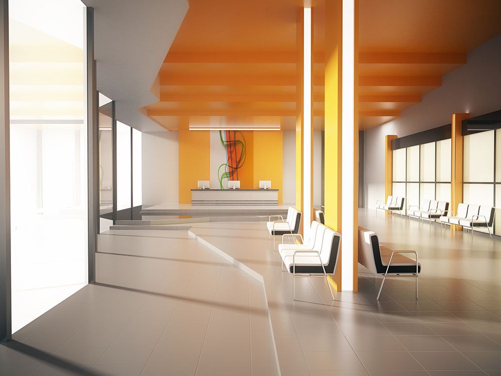 Modern lobby with orange ceiling, white walls, and black-and-white chairs in a bright, minimalist interior