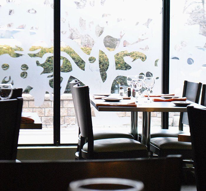 a restaurant with tables and chairs in front of a large window