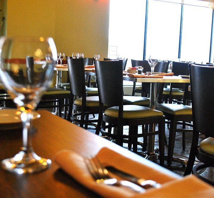 a restaurant with tables and chairs and a wine glass on the table