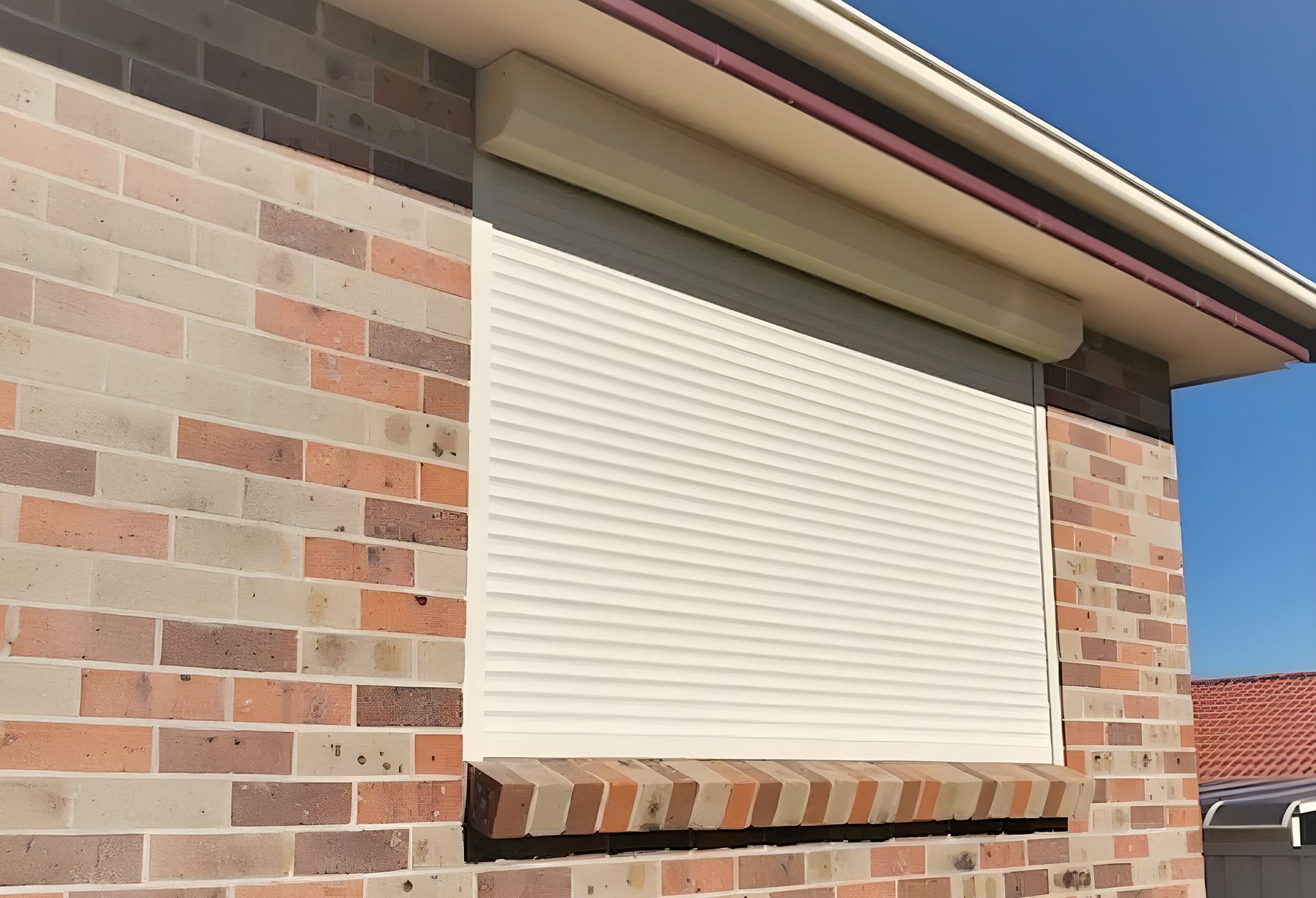 White security roller shutter on a brick house