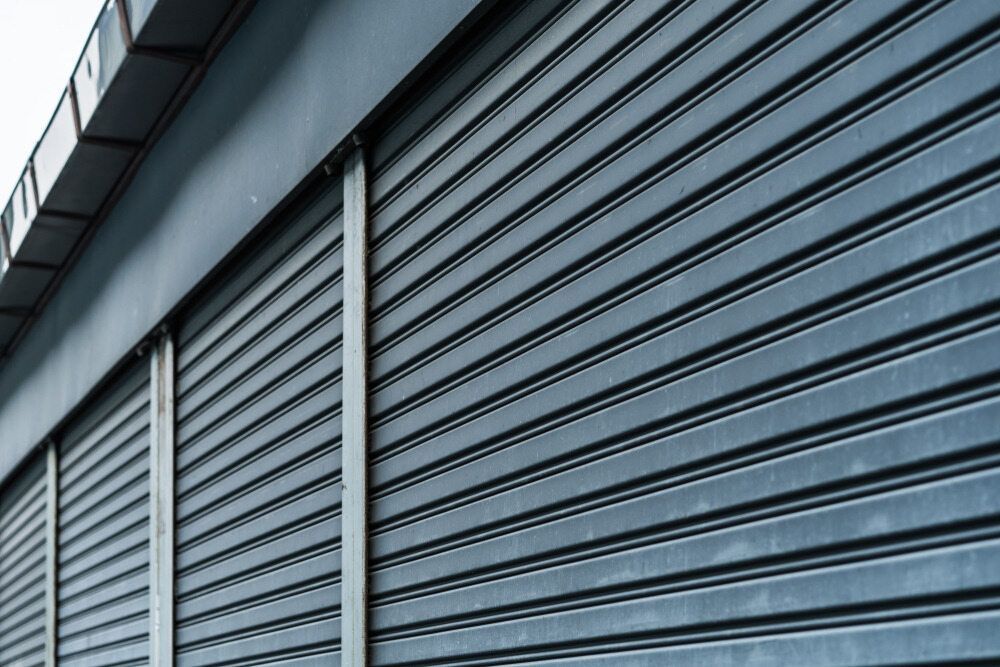A Close up Of a Metal Garage Door on A Building — Phoenix Blinds In Albion Park Rail, NSW