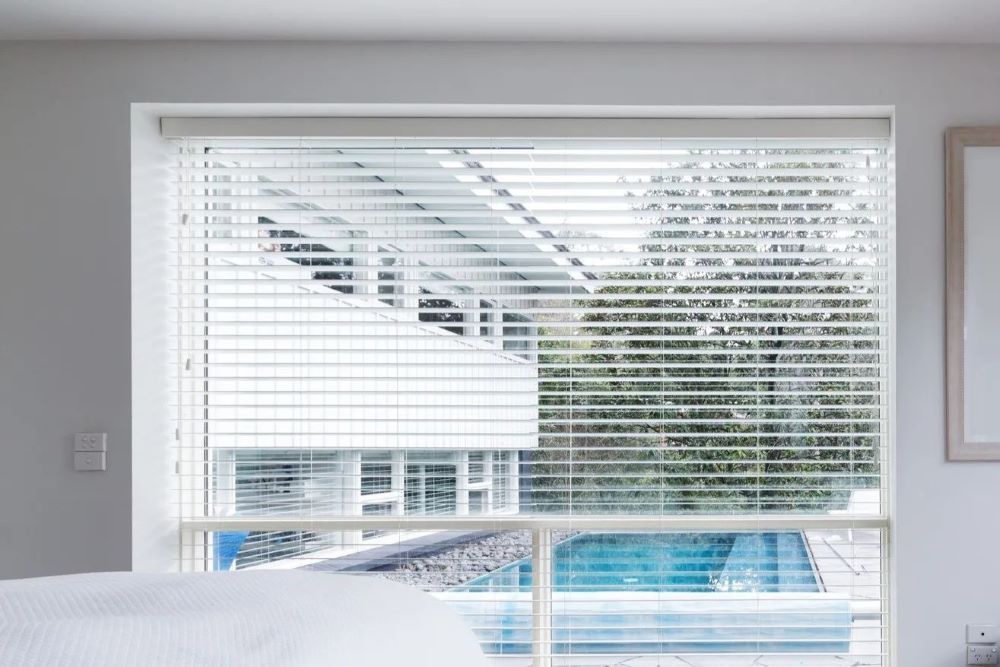 A Bedroom with A Bed and A Window — Phoenix Blinds In Albion Park Rail, NSW
