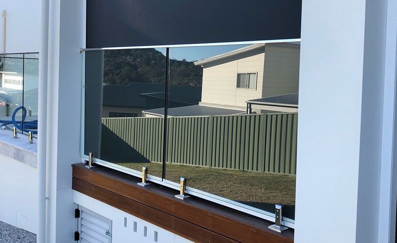 A Window with A Glass Railing and A Fence in The Background — Phoenix Blinds In Albion Park Rail, NSW
