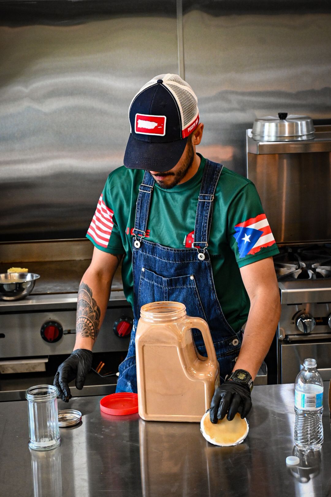 A man in overalls is preparing food in a kitchen.