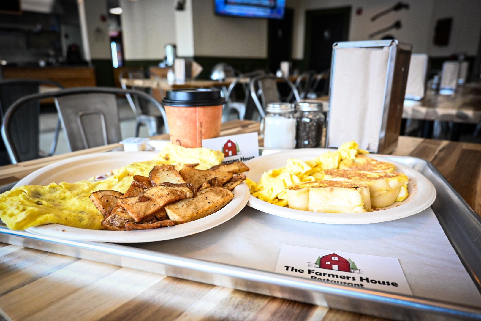 Two plates of food are on a tray on a table in a restaurant.