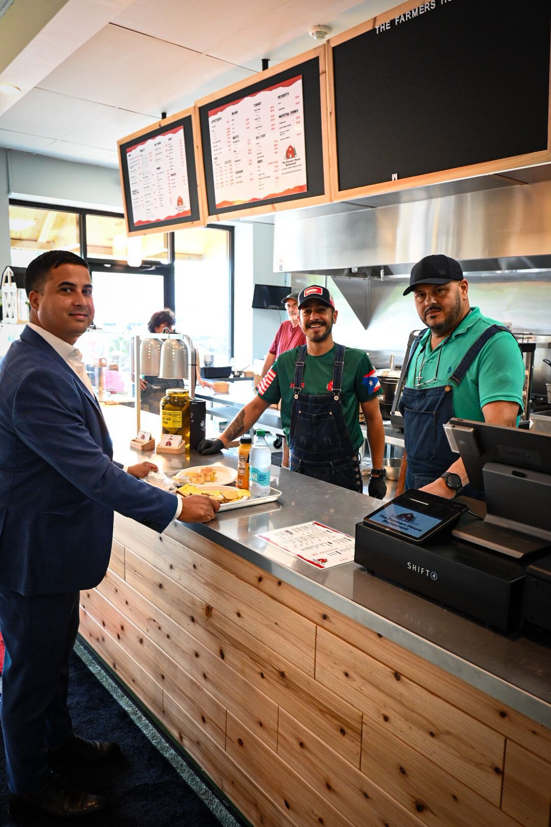 A man in a suit is standing at a counter in a restaurant.
