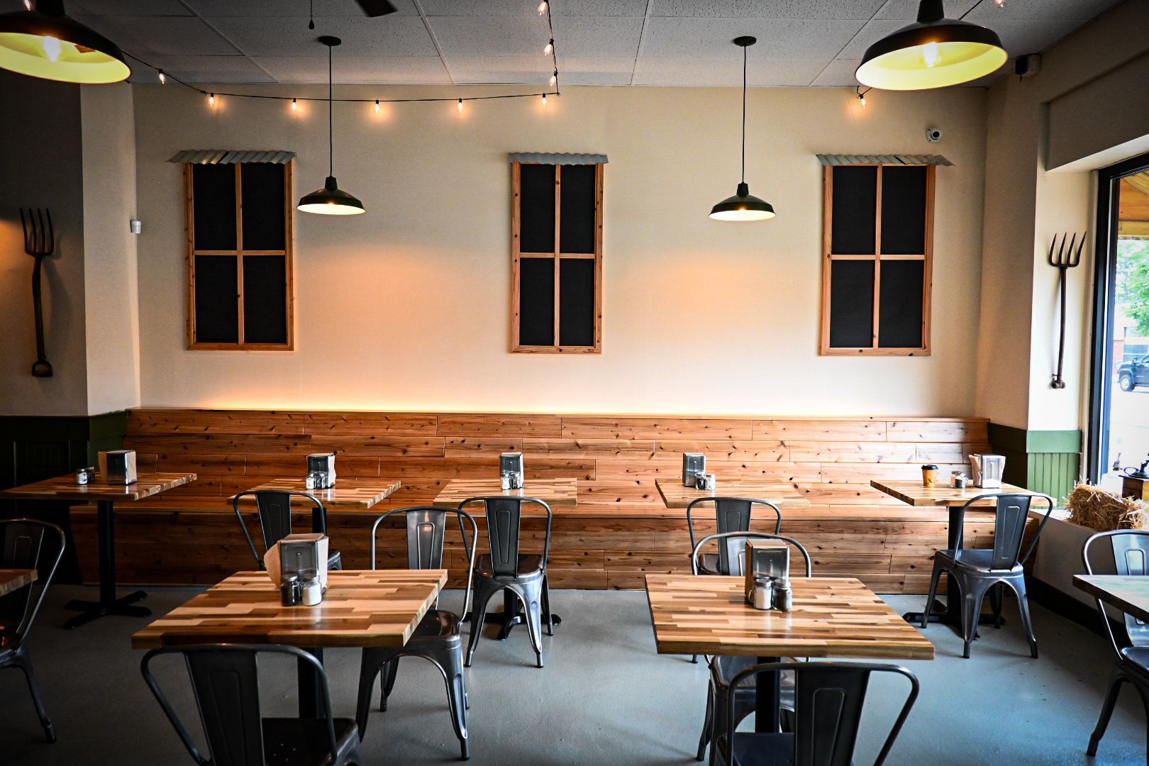 A restaurant with tables and chairs and a wooden wall.