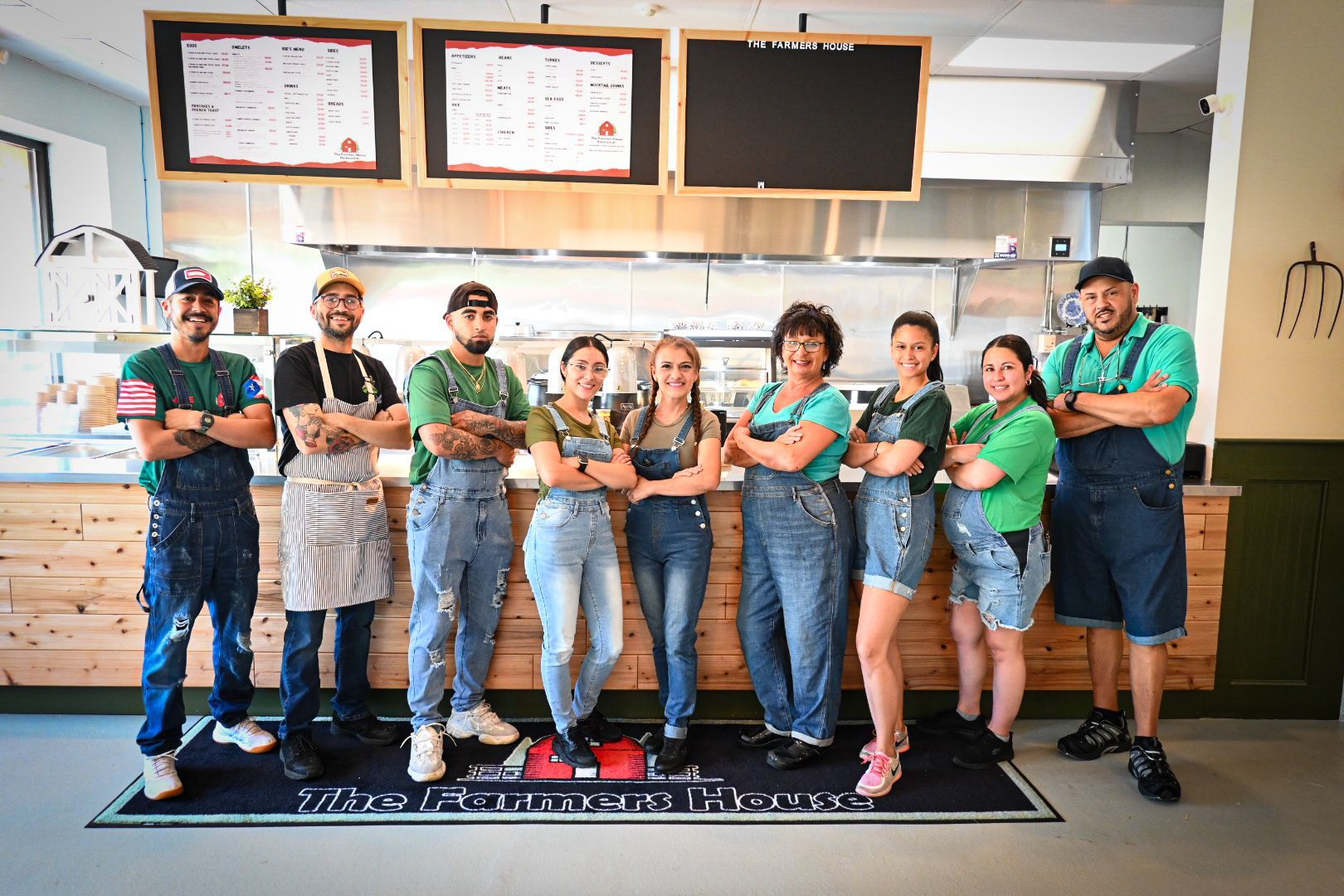 A group of people in overalls are posing for a picture in a restaurant.